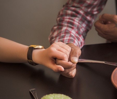 Closeup picture of man and woman holding each others hands.の写真素材