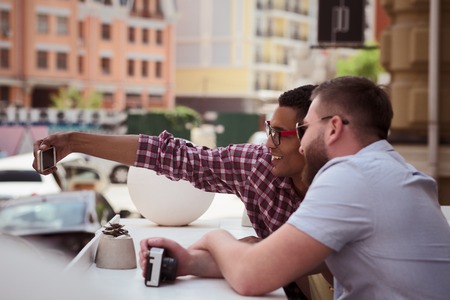 Picture of happy friends making selfies on mobile or smart phone outdoors.の写真素材