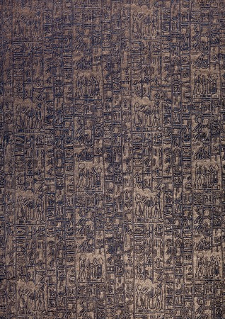 Egyptian golden hieroglyph texture closeup on dark blue paper. Grunge paper with hieroglyphics from Egypt with magnifier closeup. Dark background with golden print of hieroglyphs and letters.の写真素材