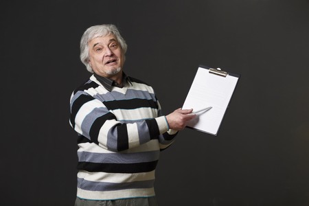 Handsome mature professor man of university or college holding clipboard and pen when explaining new theory, concept or prove in studio.の写真素材