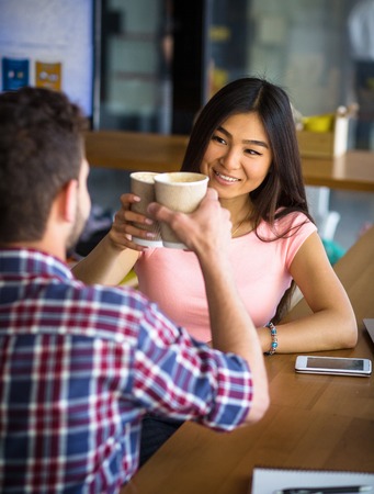 Portrait of romantic couple having date in restaurant of cafe. People sitting face to face and drinking delicious coffee.の写真素材