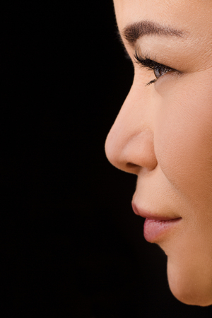 Beauty, vision, eyesight, ophthalmology and people concepts. Closeup profile of Korean or Asian woman wearing contact lenses in studio.の写真素材