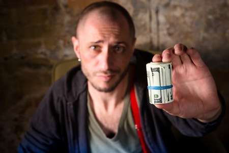 Mafiosi and laundering money concept. Drug dealer showing much dirty money received from selling drugs and narcotics.の写真素材