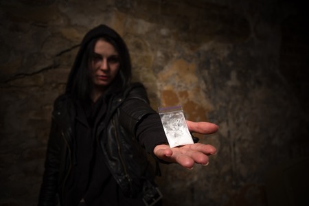 Drug addict do not know how to get rid of drug addiction. Drug addict holding narcotics or drugs and showing it to camera.の写真素材