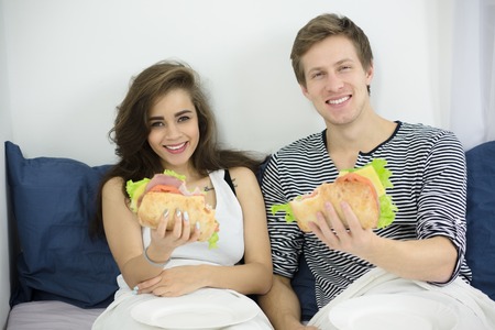 Couple eating in bedの写真素材