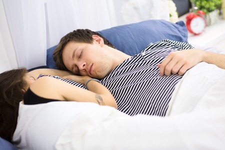 Couple sleeping on bedの写真素材