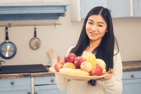 Lady with apple at homeの写真素材