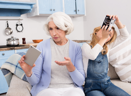 Grandmother and granddaughter making photosの写真素材