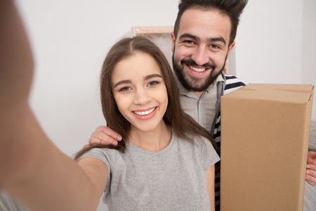 Close up portrait of young couple after relocation making selfie.の写真素材