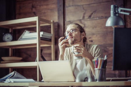 Freelancer man at his working place thinking looking up.