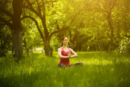 Woman relaxing, sitting on mat, practicing yoga.の写真素材