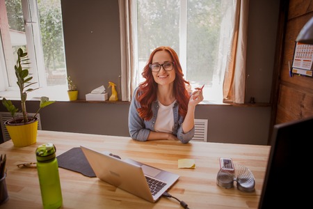 Young pretty woman sitting at home office working.の写真素材