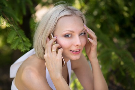 Young blond female having phone conversation.の写真素材