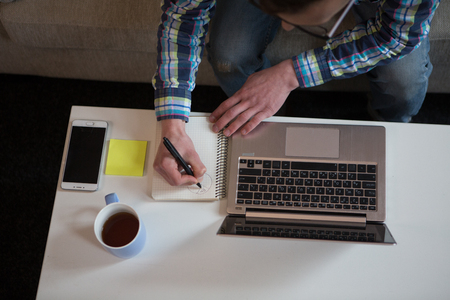 Close up view of man writing with pen in notebook.の写真素材