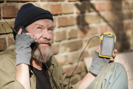 Close up view of homeless man holding solar energy battery.の写真素材