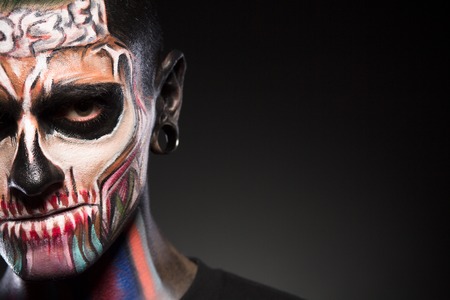 Zombie man face makeup. Creative makeup of a man isolated on black background.の写真素材