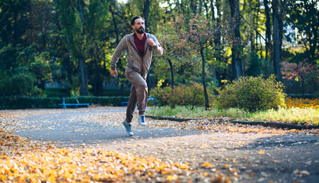 Healthy active man running in the park. Mid aged male jogging putdoors.の写真素材
