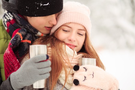 A boy whispers words of love in his girl ear. She is happy.の写真素材