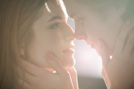 A close up potrait of two belovers looking at each other. They are going to kiss.の写真素材