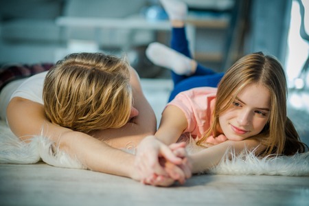 Young lovers relaxing together by holding the hands. A boy is passionately looking at his lady love.の写真素材