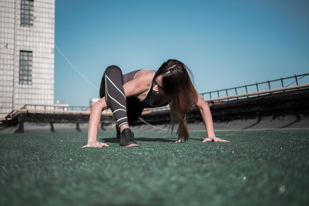 Sportive young female working out. Sport lifestyle, gym on the roof.の写真素材