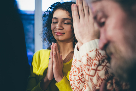 Close of of diverse people with closed eyes. Standing and praying. Toned concept.の写真素材