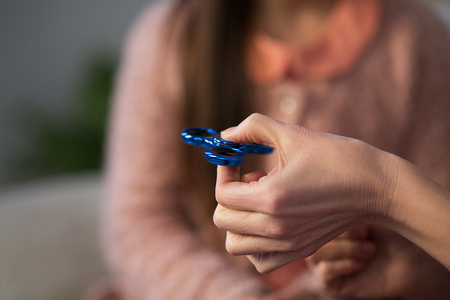 Close up of middle aged woman hand holding spinner. Ttrend toy concept.の写真素材