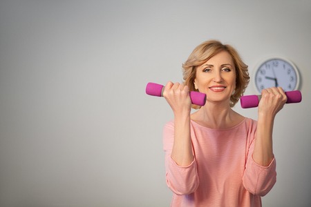 Half length image of woman making exercise with drumbells. Healthy lifestyle concept.の写真素材
