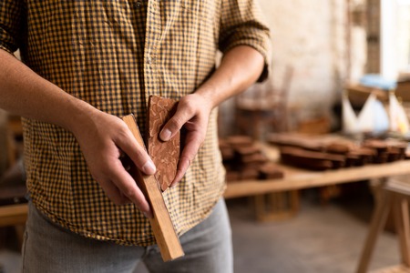 Close-up view of the wood carpenters hands. Hands of a joiner, who holds two bricks of wood. Wooden blanks for boat.の写真素材