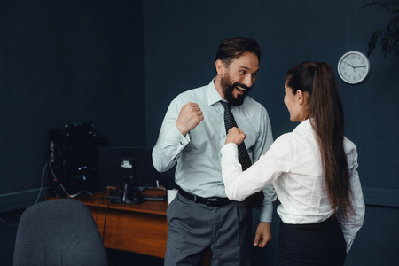 Young business people in office clothes showing fists to each other. Fight of genders concept.