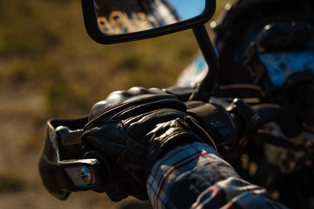 Detailed view of a bikers hand in lether glove. On the road.の写真素材
