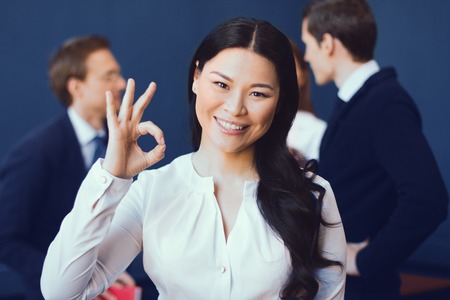 Smiling Business Woman In White Blouse Showing Ok. Signed Profitable Agreement. Business Concept.の写真素材