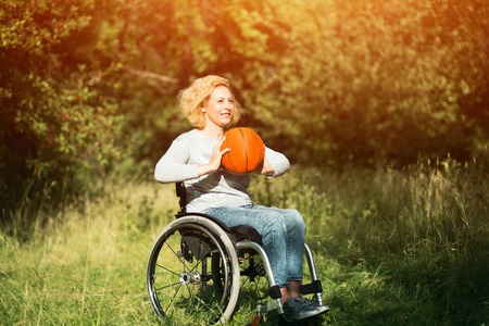 Cheerful Girl In Wheelchair Is About To Throw A Basket Ball. Recovery Concept, Disability And Sport