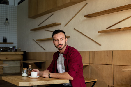 Handsome Man Having Coffee At Cafe. Sitting At Table And Waiting For Girl.
