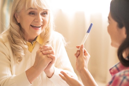 Happy Elderly Mother Sees Negative Results Of Her Daughters Pregnancy Test