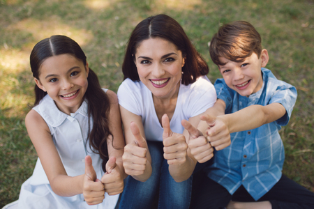 Teacher And Children Showing Thumbs Up After Having Lesson In Park. Creative Education Concept.の写真素材