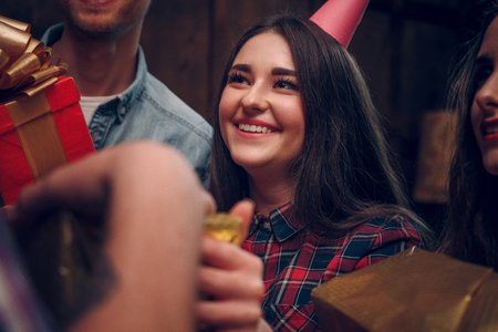 Excited and cheerful young girl in a party hat smiles and enjoys her time at a birthday partyの写真素材