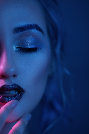 Seductive Womans Face With Night Makeup. Close-Up Of Beautiful Blonde Girls Face Touching Her Dark Red Lips With Fingers. Half Of Sexy Womans Face With Vamp Makeup.の写真素材