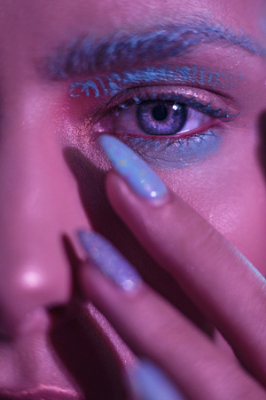 Young girl with bright blue eyes. Hands with a bright manicure around the face. Close Up Shoot.の写真素材