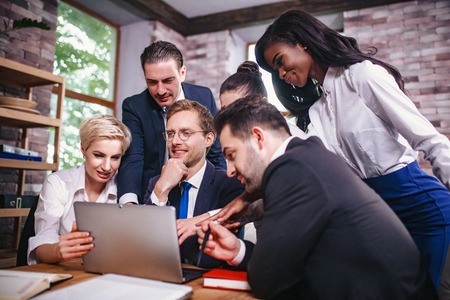 Charming Team Of Business People Gathered Around Laptop Discussing Ideas. Concentrated Man In...