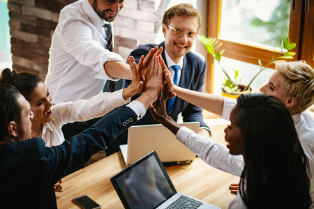 Top View Of Happy Colleagues Joining Their Hands To Celebrate A Success. Cheerful Businesspeople Join Hands Rejoicing Their Workの写真素材