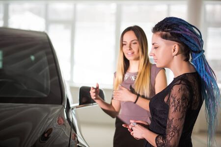 Woman Choising Brand New Car in Auto Show. Sexy Female is Making Purchase of Luxury Car. Girl with Blue Dreads is Looking for Perfect Car to Buy. Kyiv, Ukraine, F-Drive showroom 13 of february 2018.のeditorial素材