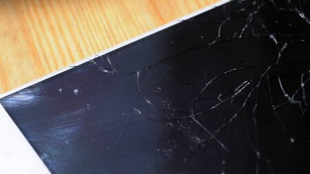 Xiaomi MI Max smartphone with broken screen matrix lies on wooden table. Closeup photoshot shows chaotic shining fractures and fingerprints leftovers on black display Kyiv, Ukraine, 6th of June 2019のeditorial素材