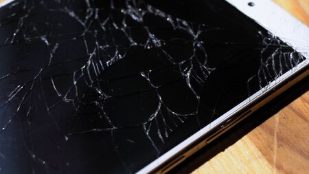 Xiaomi MI Max smartphone with broken screen matrix lies on wooden table. Closeup photoshot shows chaotic shining fractures on black display Kyiv, Ukraine, 6th of June 2019のeditorial素材