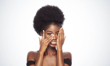 Smiling Afro Model in Beauty Concept Isolated on White Background. Girl With Afro Hairstyle Smiling Covering Face With Hands.の写真素材