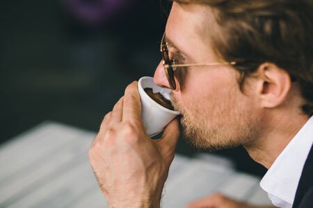 Bearded Man In Sunglasses Is Drinking Coffee Closeup Shot. Attractive Young Guy Is Enjoying His Cup...