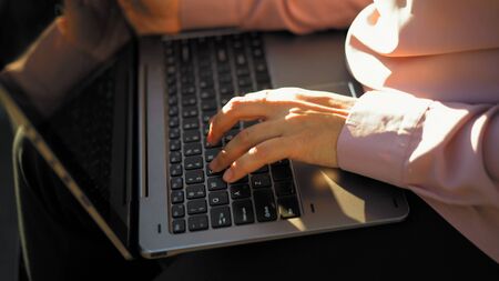 Beautiful Womens Hands Type Text in a Laptop. Hands hold the laptop. Close Up Concept.