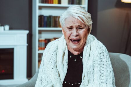 Old Lady Laughs Amusedly Opening Her Mouth And Closing Her Eyes. A Woman Threw A White Plaid Over...