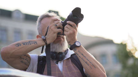 An Adult Hipster With Tattu Takes A Picture Of The City During A Summer Trip.の写真素材