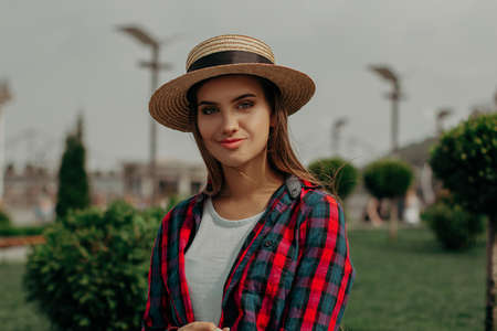 The Student Relaxes In Nature. Intelligent Young Girl In A Bright Plaid Shirt Walks In The Park During The Summer Holidays.の写真素材
